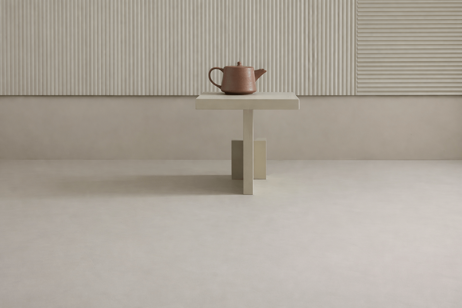 Sol en linoléum clair dans un espace minimaliste, avec une table épurée et une théière en céramique.